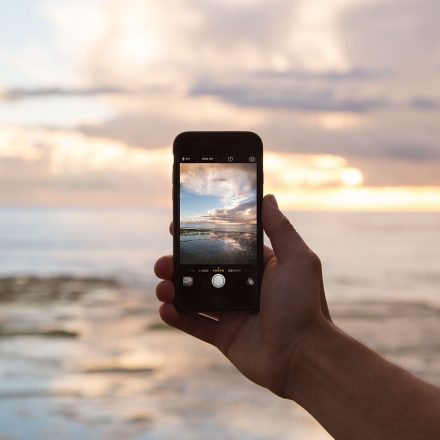 Touchscreen phone taking picture of the ocean at sunset Empowering Students to Stop Cell Phone Addiction Teaching Strategies for Today’s Students (iGen or GenZ)
